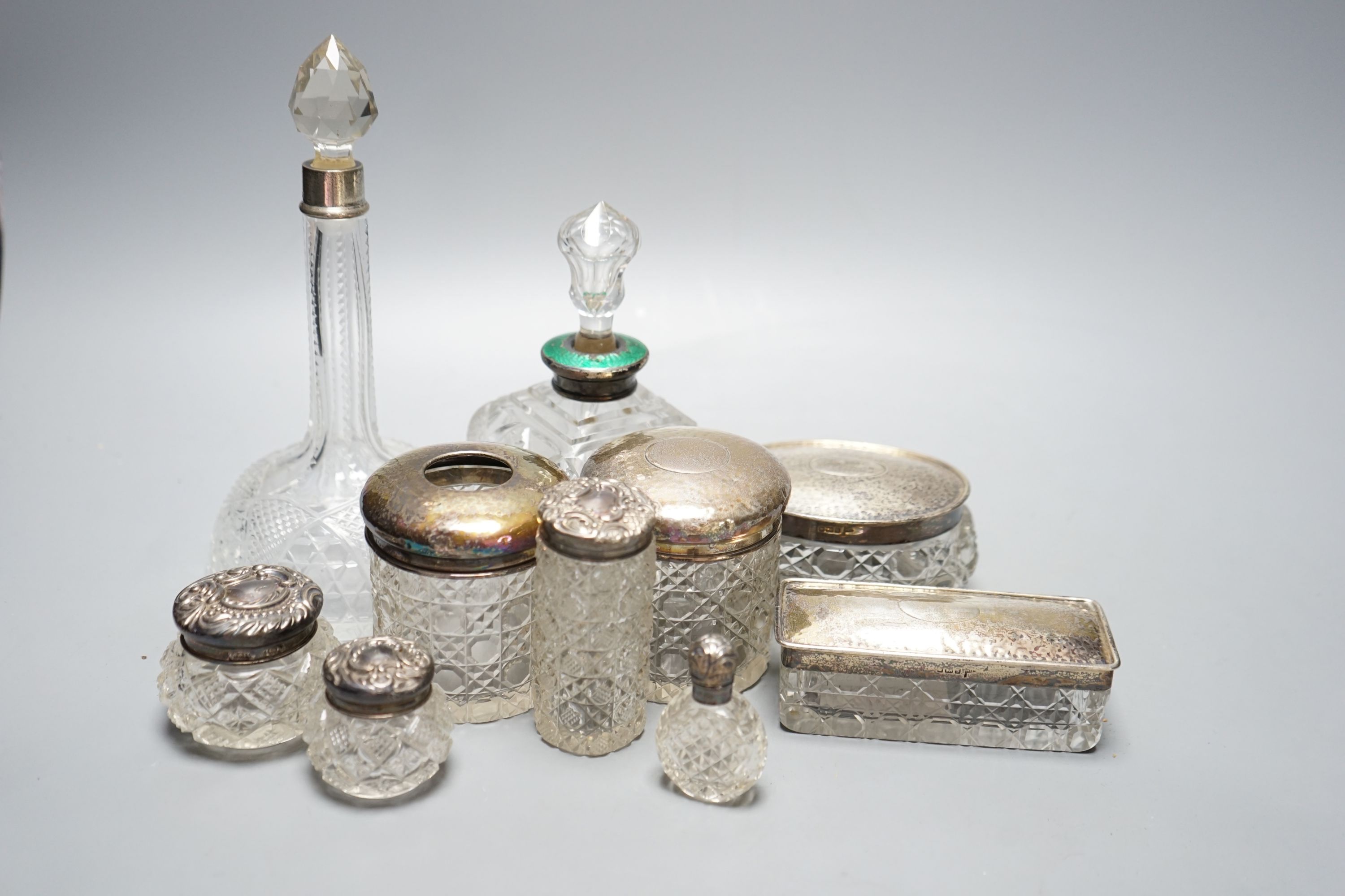 Two silver mounted cut glass scent bottles, including enamel(a.f.) and eight various dressing table items with silver lids.